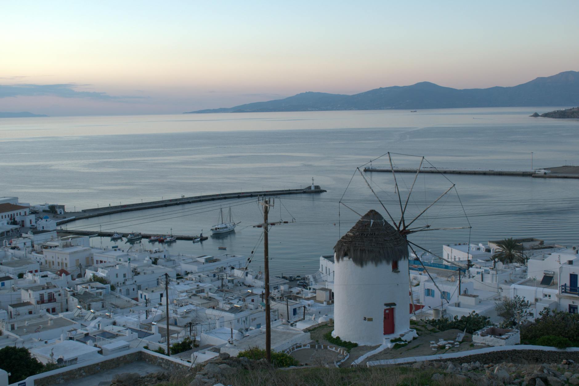 Sunset view over Mykonos Town white Cycladic buildings with iconic windmills
