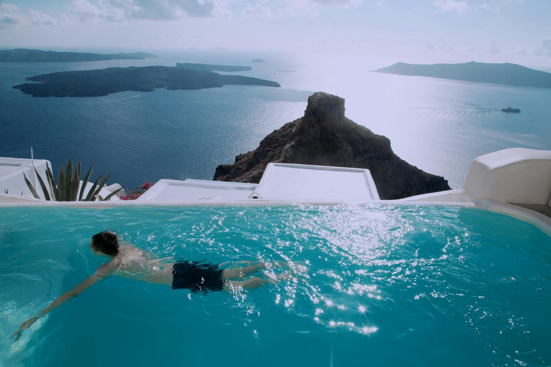 Luxury Santorini hotel infinity pool overlooking the deep blue caldera with white buildings