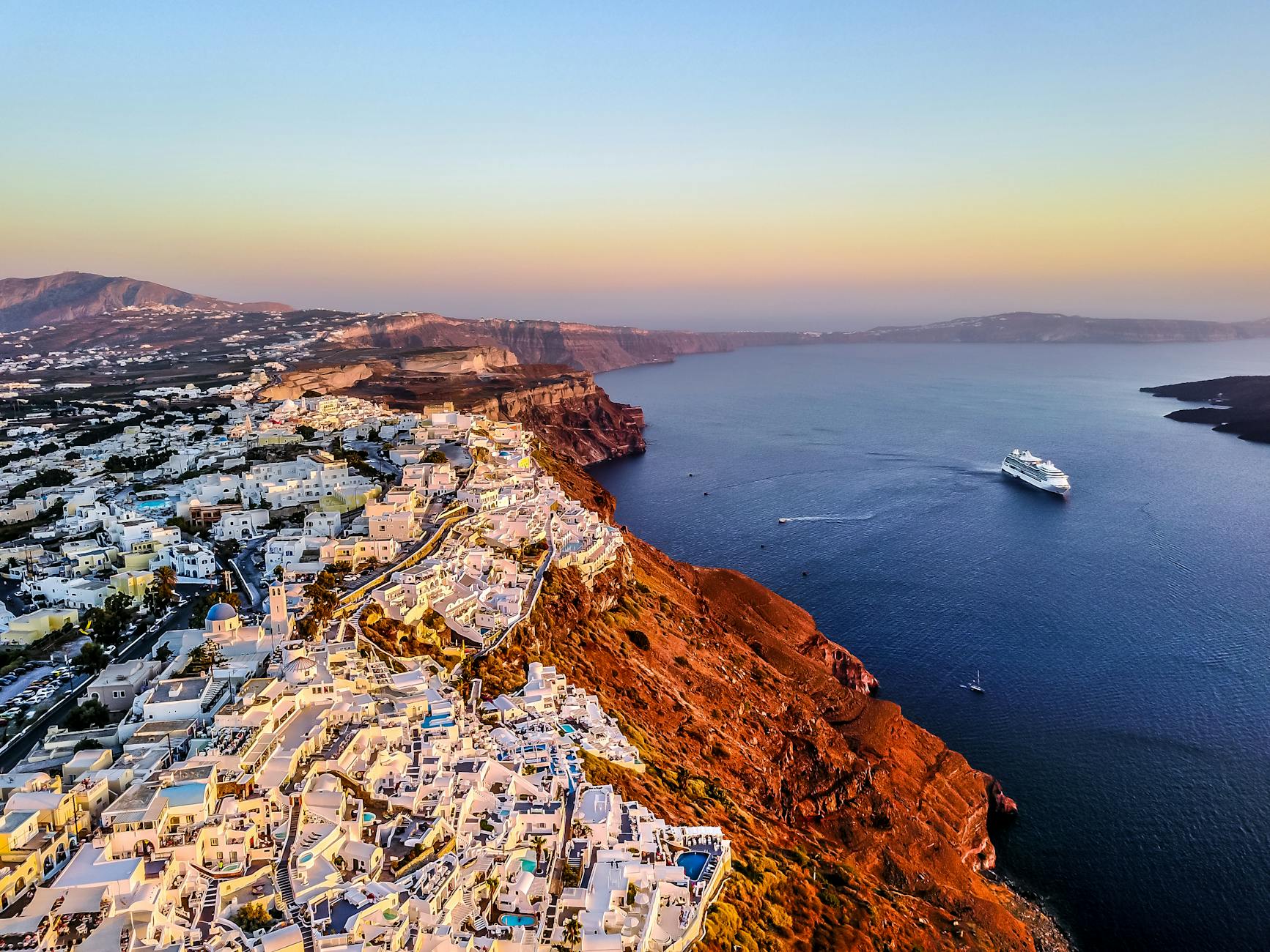 Traditional Greek hotel terrace in Oia with caldera view and sunset colors