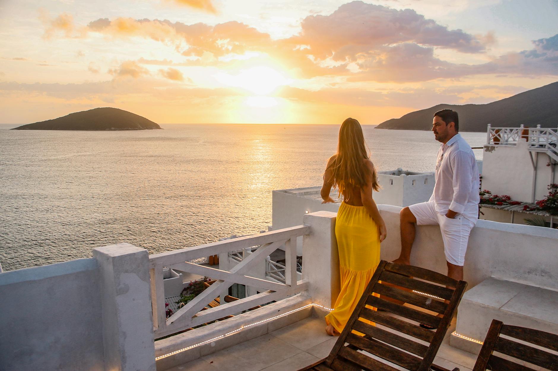 romantic hotels greece featuring couples on luxury terrace overlooking aegean sea at sunset